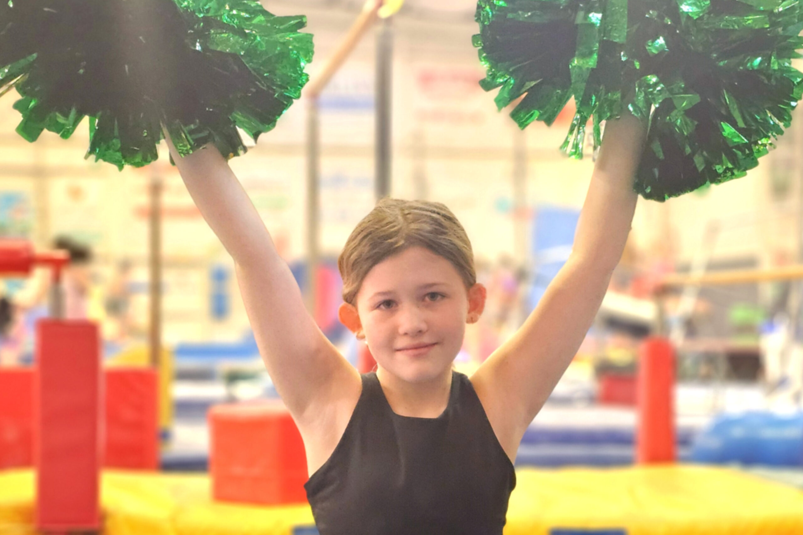 Girl using pom poms in a cheerleading class